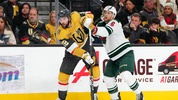 Minnesota Wild defenseman Dakota Mermis (6) checks Vegas Golden Knights right wing Michael Amadio (22) during the second period at T-Mobile Arena in Las Vegas on Feb. 12, 2024.